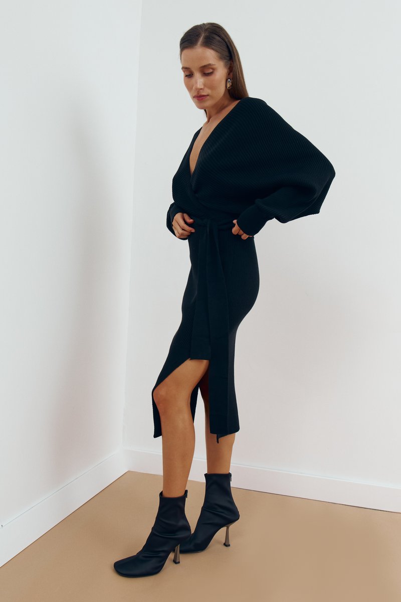 

Чорна трикотажна сукня міді на запа́х