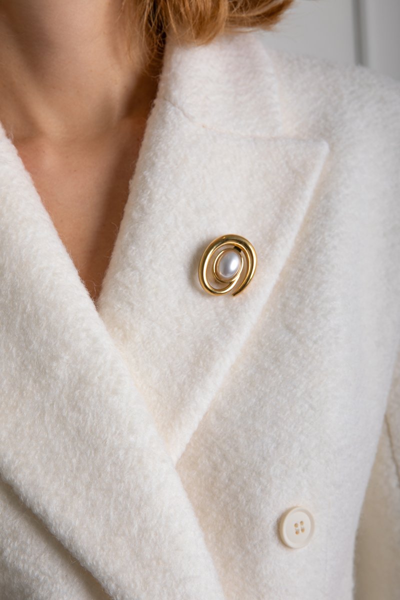 

Золотиста брошка овальної форми з перлиною