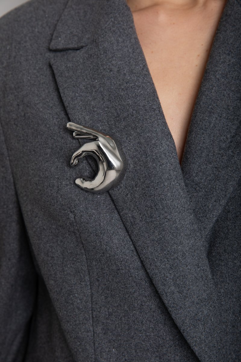 

Срібляста брошка у формі руки