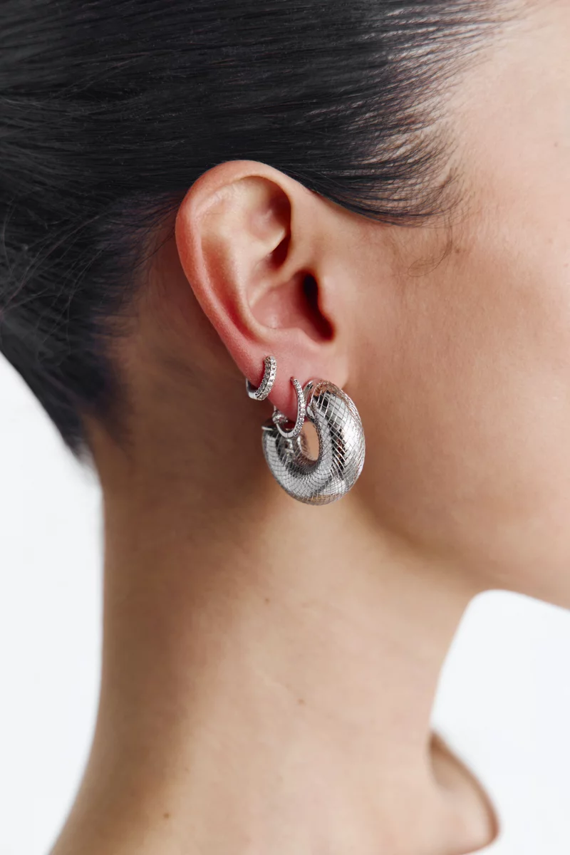 Серебристые текстурные серьги круглой формы фотография 1