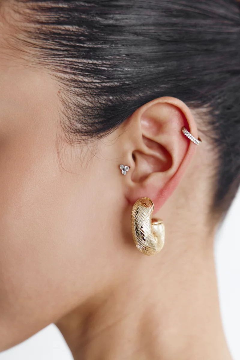 Золотистые текстурные серьги круглой формы фотография 1