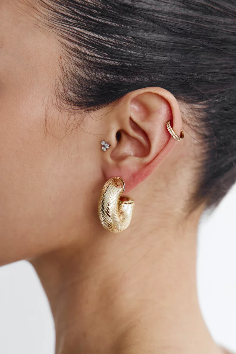 Золотистые текстурные серьги круглой формы фотография 3